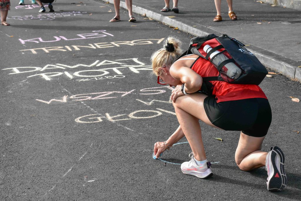 Supporting triathletes by writing their names or messages in chalk on Aliʻi Drive right before the finish line has become a tradition for the Ironman World Championship in Kona. (Cammy Clark/Big Island Now)
